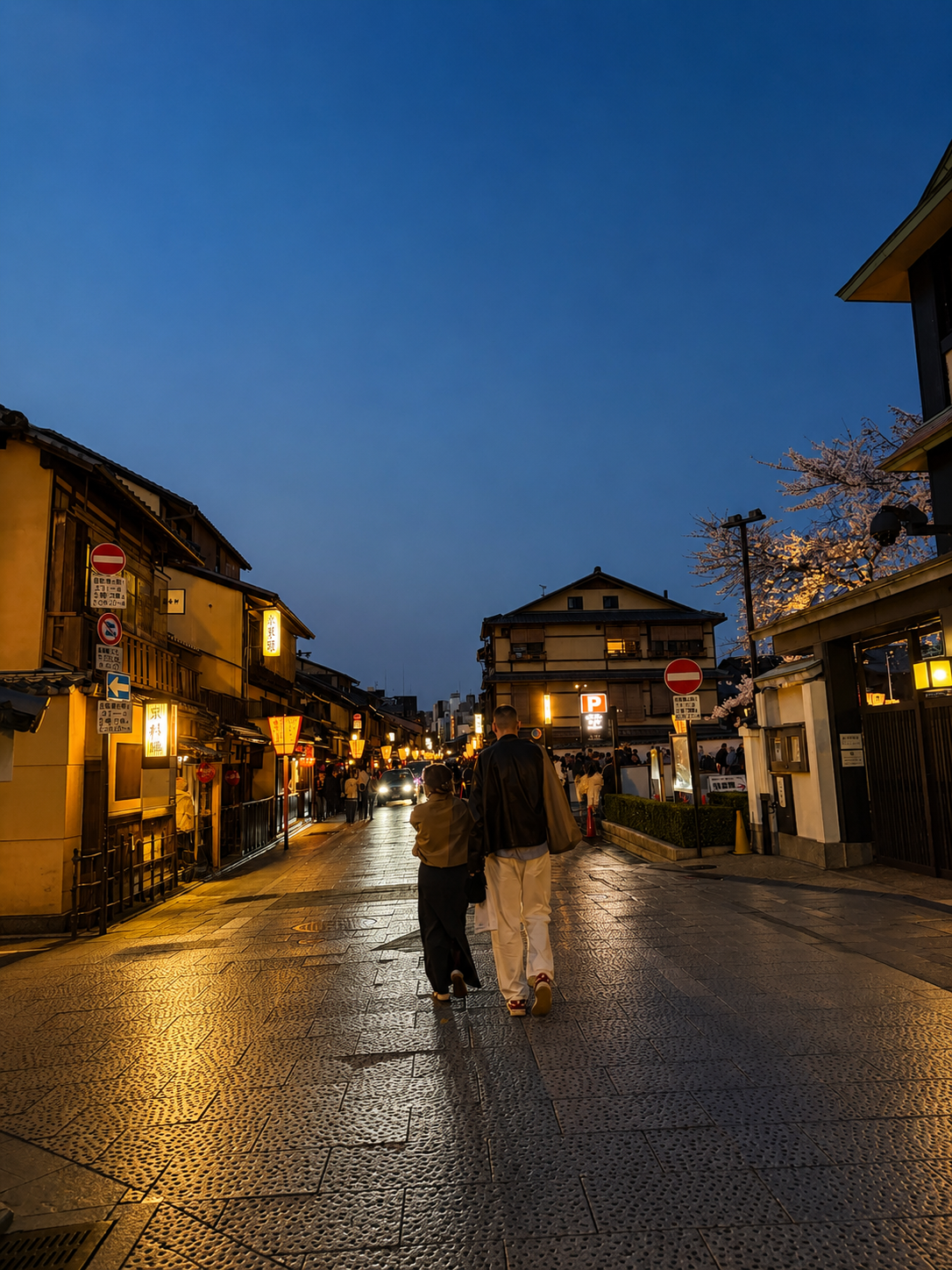 A Gion street at blue hour, two people walking, warm-lit shopfronts, deep blue sky