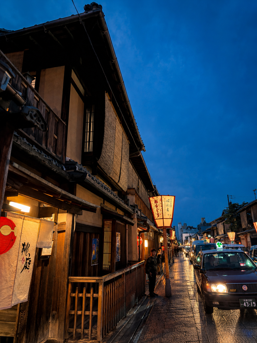 A cinematic Gion lane at dusk, machiya facades, a glowing red lantern, a taxi's headlights, wet stone